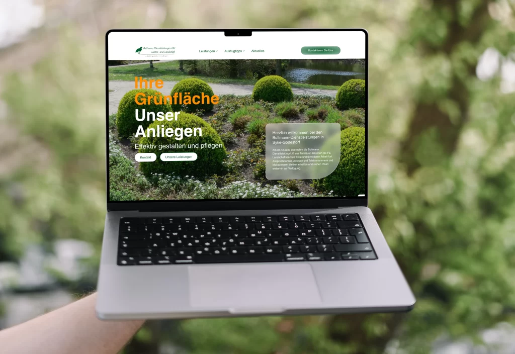 Eine Hand hält ein MacBook Pro, das eine Website mit Landschaftsgestaltung zeigt.
