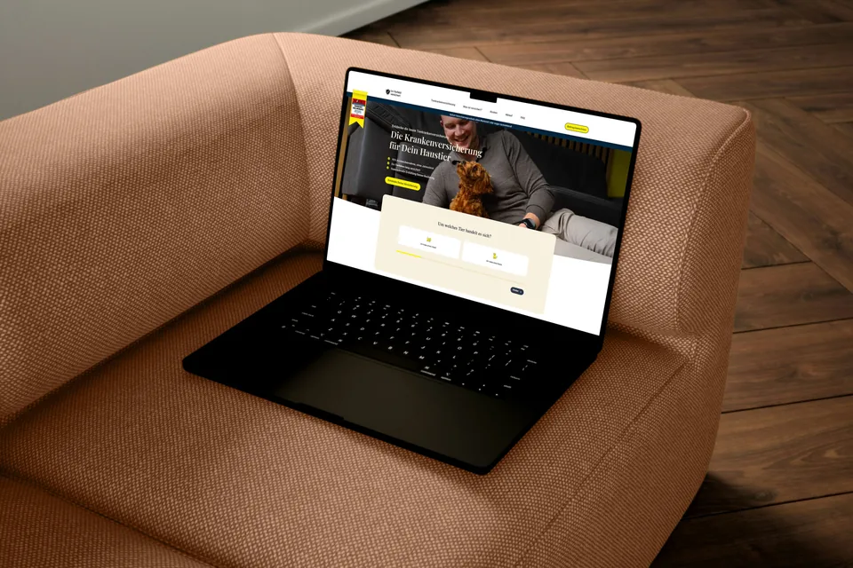 Laptop auf einem rostroten Sessel, auf dem Bildschirm die Landingpage von Im Vorfeld versichert mit Hero-Foto und der Frage „Um welches Tier handelt es sich?“